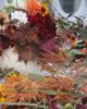 A vibrant autumn bouquet with various colorful leaves and flowers.