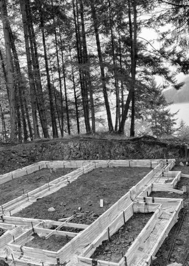 Wooden forms set for concrete foundation in forest area.