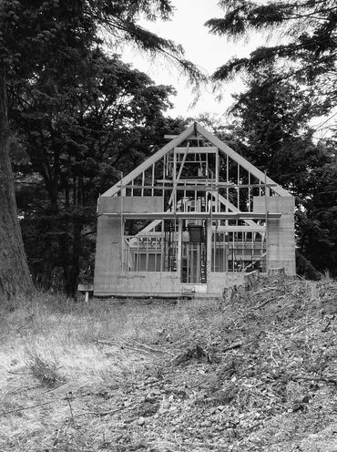 A house under construction framed by trees.
