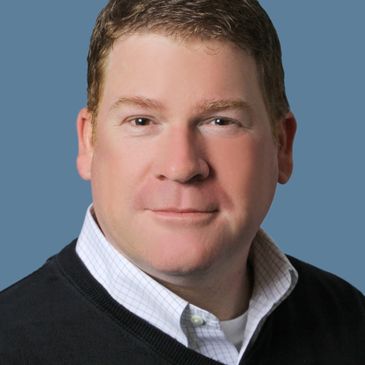Professional headshot of a man with a confident expression.