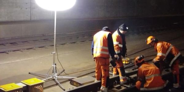 Workers repairing railroad tracks at night.