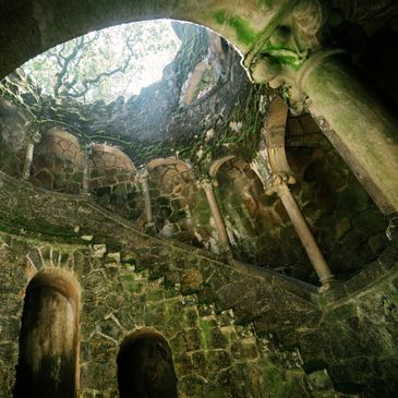 Ancient moss-covered stone staircase inside a circular ruin.