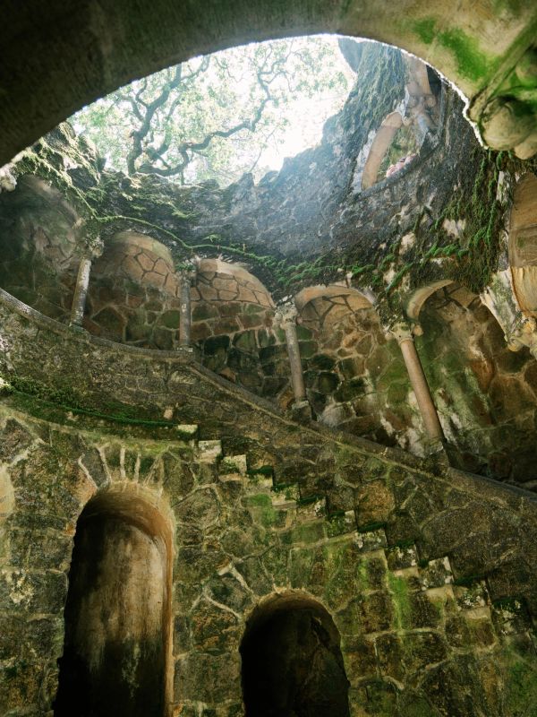 Ancient moss-covered stone staircase inside a circular ruin.