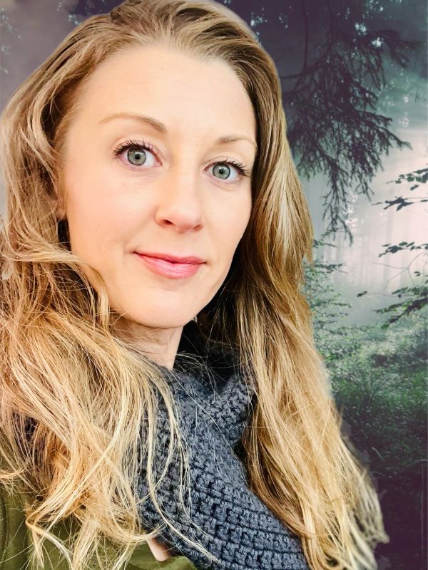 Woman with long hair in a forest setting.