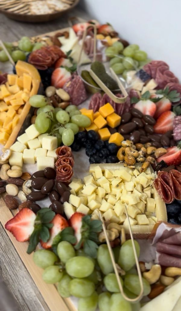Close-up of a charcuterie board with cheeses, fruits, nuts, and meats.