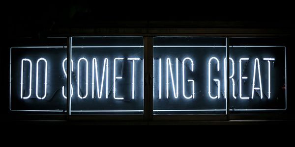 Neon sign glowing with the motivational phrase 'DO SOMETHING GREAT'.