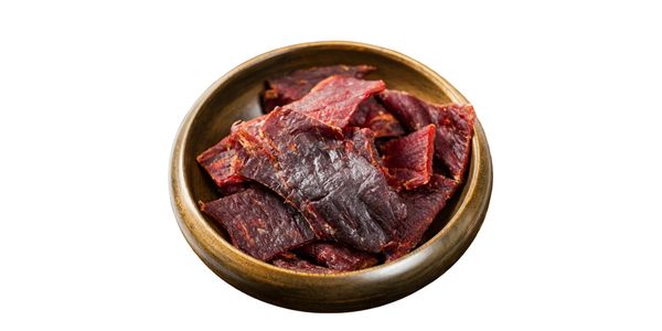 A wooden bowl filled with dark red beef jerky strips.