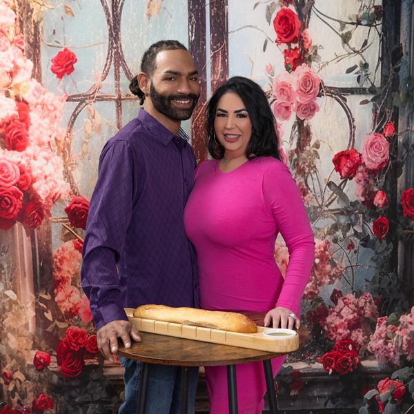 A man and woman Standing and Smiling with looking ahead Behind the Birthday decoration