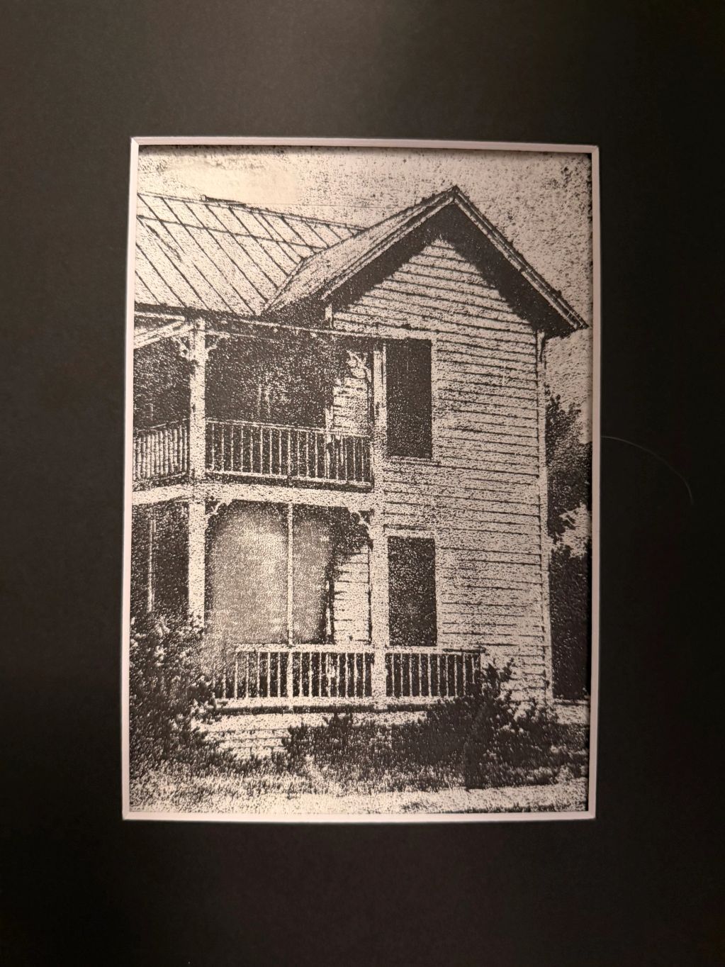 Black and white photo of a two-story house with a porch.