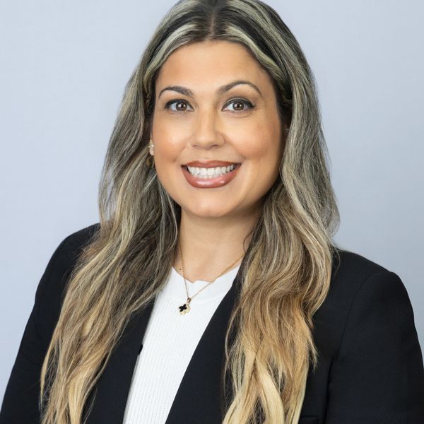 Professional woman with long blonde hair smiling in a black blazer.