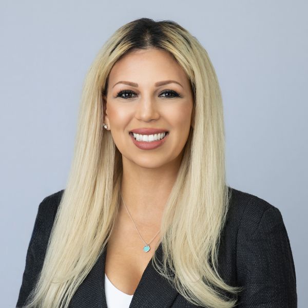 Professional woman with long blonde hair smiling confidently.