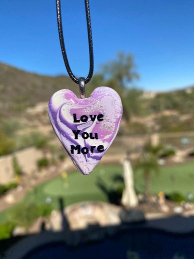 Clay necklace in lavender, white and purple with "I love you more" with a 21" adjustable black cord 