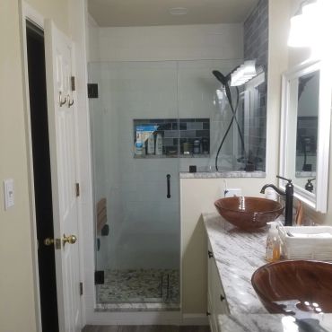 Modern bathroom with glass shower and brown vessel sinks.