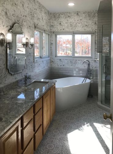 Bright bathroom with freestanding bathtub and wooden cabinets.