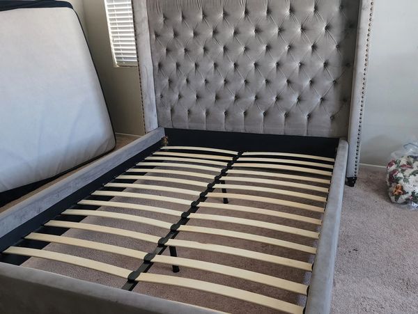queen bed being put together in room with no mattres