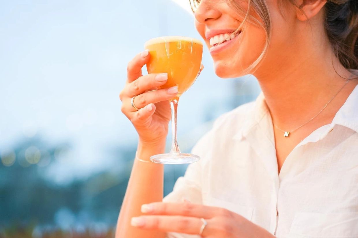 Woman smiling and holding a glass of orange juice.