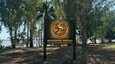 Signboard for Alnagith Corporation Residential Rentals in a wooded area near water.