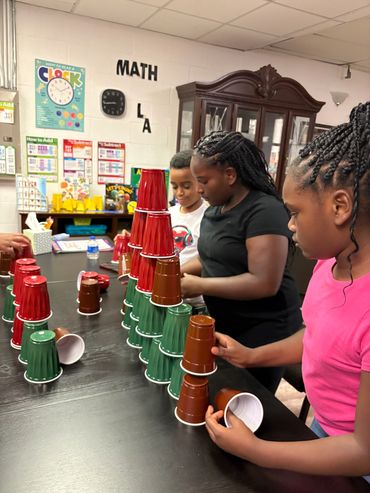 Children stacking colored cups in a classroom.