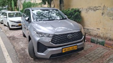 Silver Toyota SUV parked on a street with a yellow license plate.