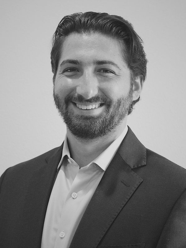 Smiling man in business attire posing for a professional headshot.