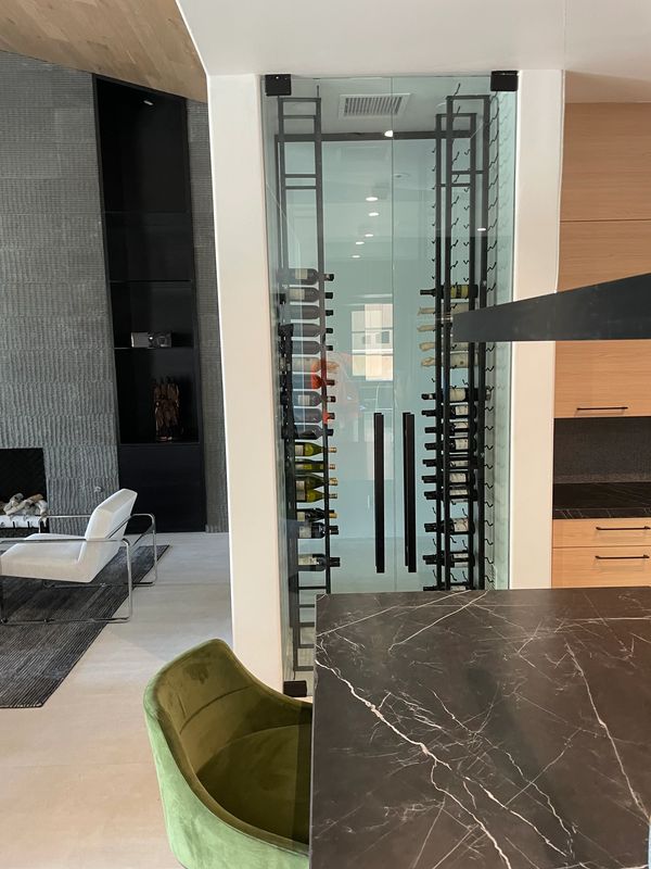 Custom frameless glass wine room with matte black commercial hardware 