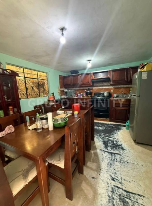 Cocina sencilla con mesa de madera y estufa negra.