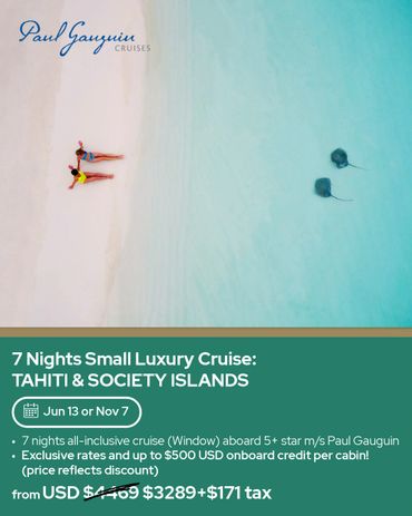 Two people relax on a beach near stingrays in clear water.