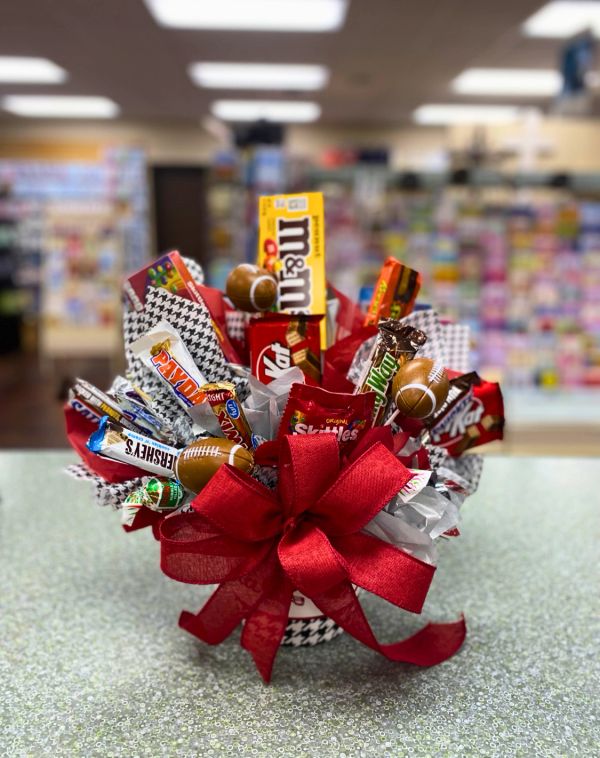 Candy bouquet with football-themed decorations and a large red bow.
