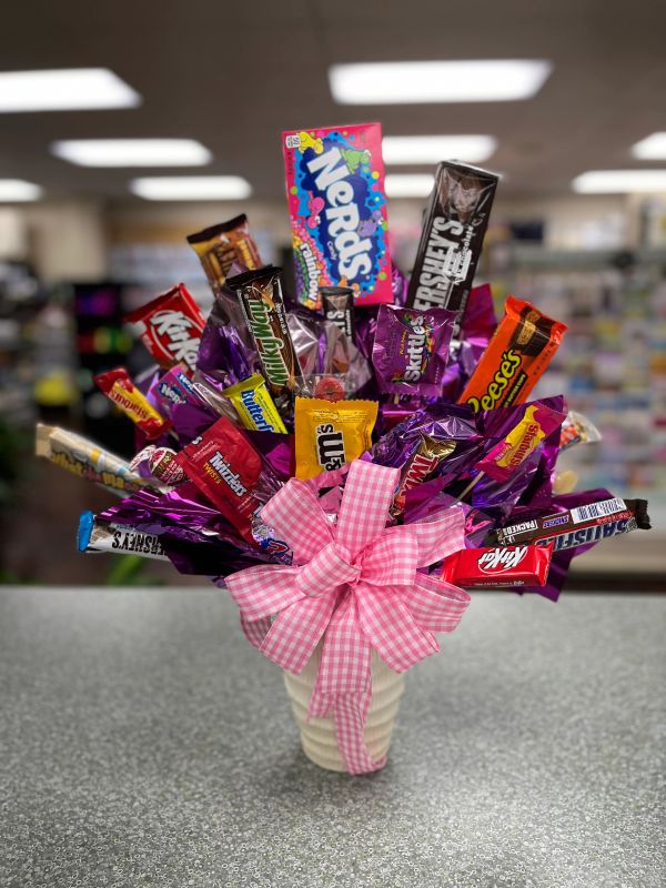 A candy bouquet with assorted chocolate bars and a pink checkered bow.