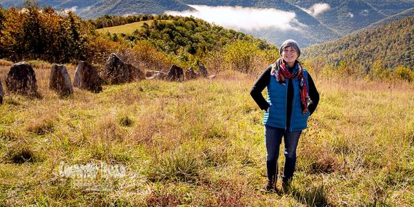 Woman on hill top which overlooks more hills.