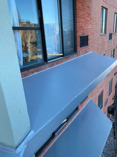 Newly painted metal awnings on a brick apartment building.