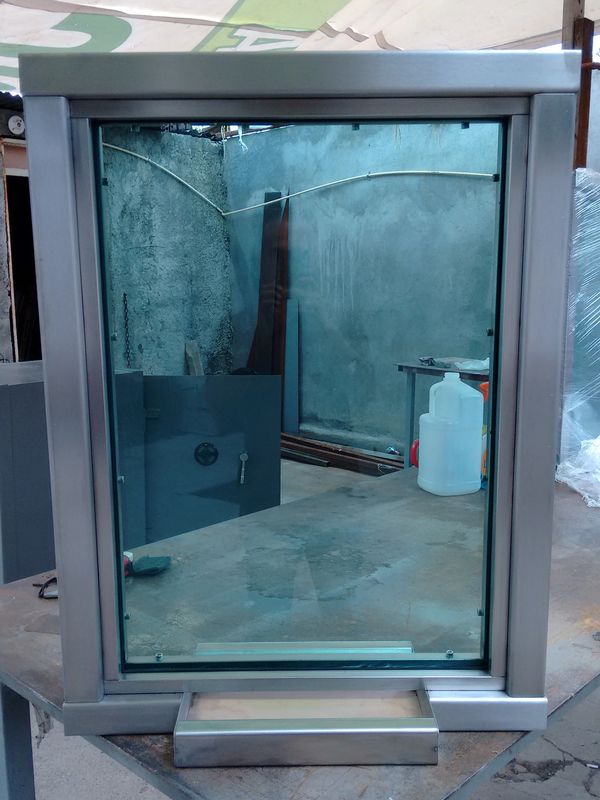 A rectangular glass window with a metallic frame placed on a table.