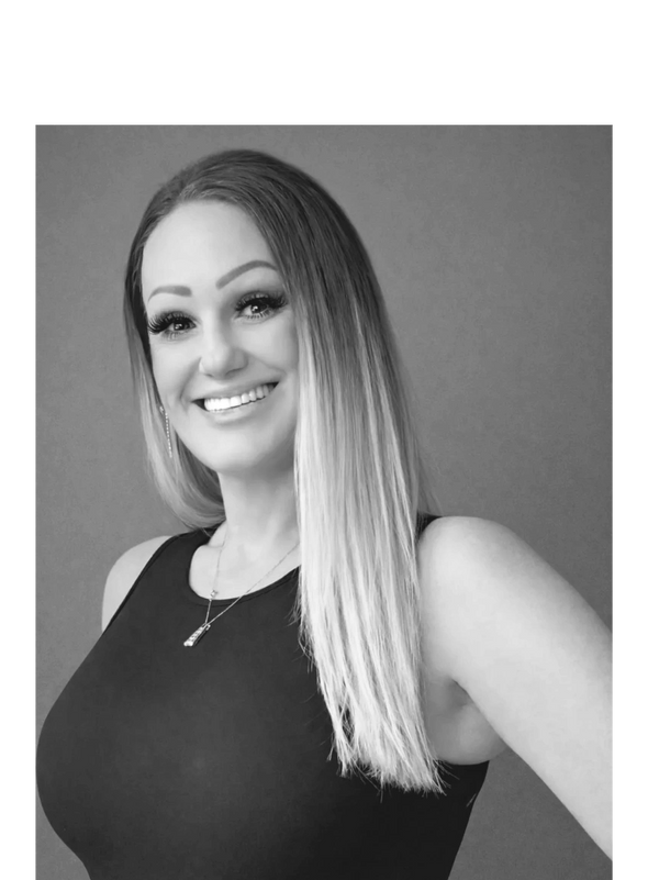 Smiling woman with long blonde hair wearing a black sleeveless top.