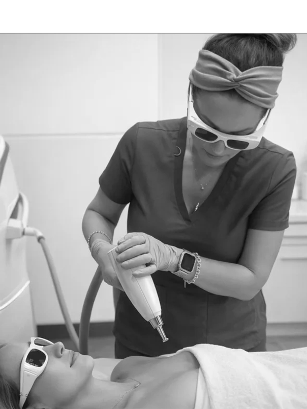 A woman receives laser treatment on her chest from a professional in a clinic.