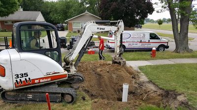 Sewer Backup.  Excavating.  Dig.  Professional on a machine. Go-To Pro Plumbing