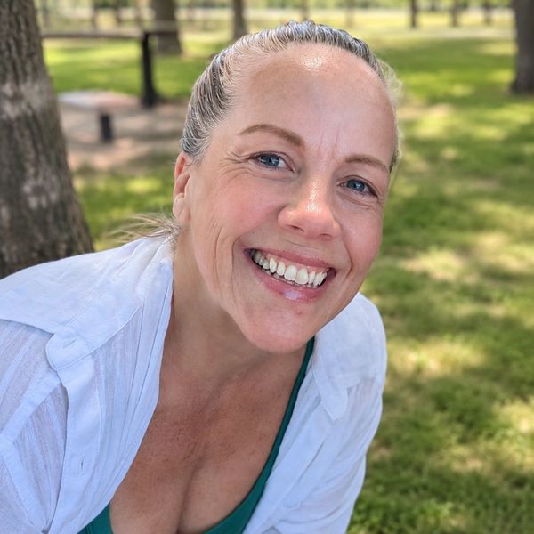 Smiling woman outdoors on a sunny day.