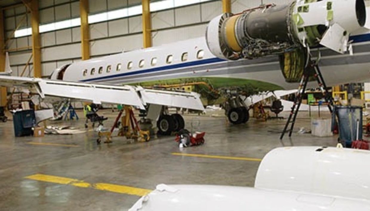 An aircraft getting repaired inside a garage