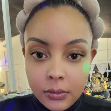 Close-up of a woman with a headband and natural makeup indoors.