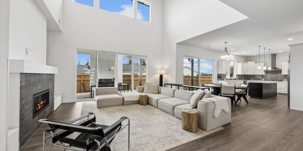 Modern open-concept living room with high ceilings and fireplace.