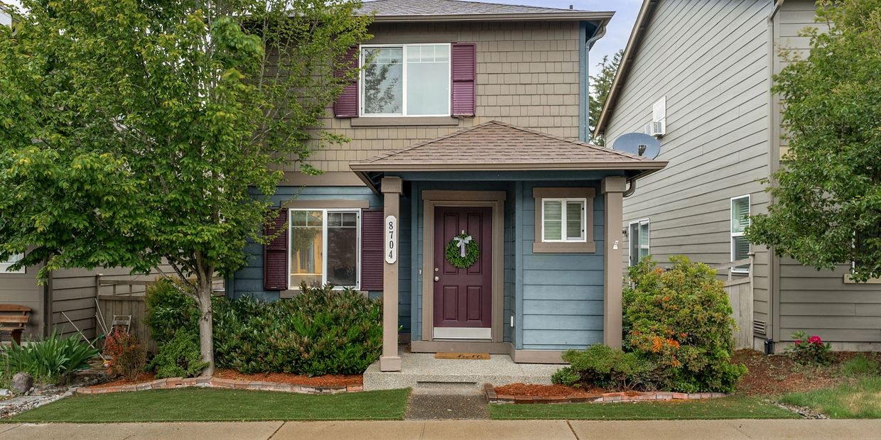Charming two-story house with a purple door and green wreath.