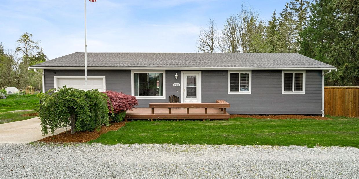 Single-story gray house with white trim and a wooden deck in front.