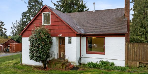 Small white house with red roof accents and a front porch.