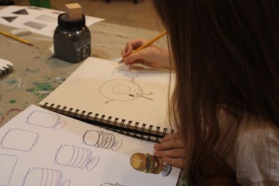 Close up photograph of a child drawing a sentient donut. 