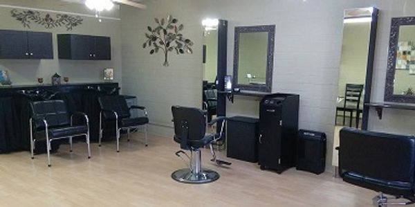 Interior of a clean, modern hair salon with styling chairs and mirrors.