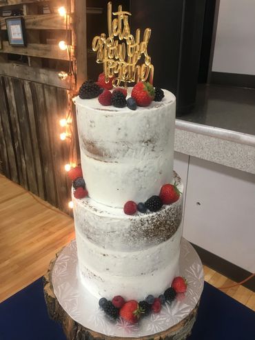 2 tier semi naked buttercream cake with fresh fruit and acrylic topper. 