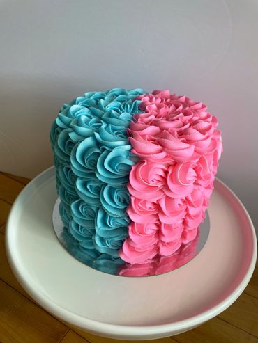 A blue and pink rosette buttercream cake for a gender reveal. 