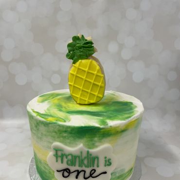 Green, yellow and white buttercream smash cake with a fondant pineapple cookie on top. 