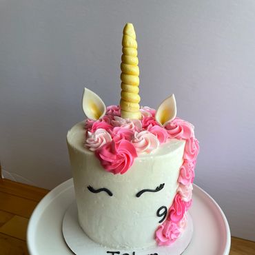 Unicorn buttercream kid's birthday cake with fondant ears and horn. 