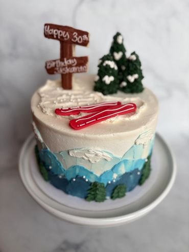 Ski theme buttercream birthday cake with fondant skis and details. 