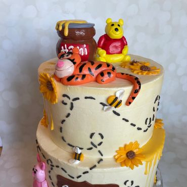 Two tier Winnie the Pooh theme kids birthday cake with fondant characters. 